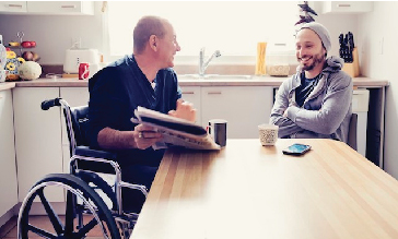 Two men talking at a kitchen table