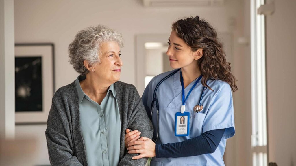 Female Nurse helping elderly woman