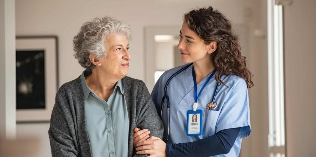 Female Nurse helping elderly woman