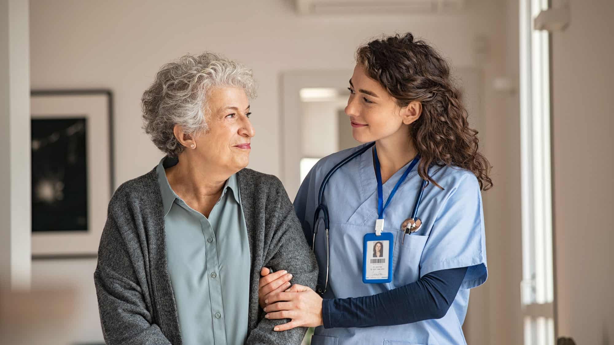 Female Nurse helping elderly woman