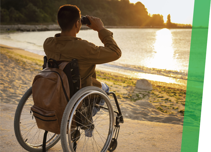 Disabled Man on beach in wheelchair with backpack